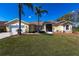 Charming single-story home with a well-manicured lawn and beautiful palm trees under a clear blue sky at 255 San Cristobal Ave, Punta Gorda, FL 33983
