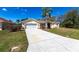 A charming single-story home showcasing a long driveway leading to an attached two-car garage at 255 San Cristobal Ave, Punta Gorda, FL 33983