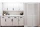 Bright kitchen with sleek white cabinets and countertops, complemented by stylish hardware and shelving at 255 San Cristobal Ave, Punta Gorda, FL 33983