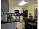 Well lit kitchen featuring white cabinets, a modern stainless steel oven, and black countertops at 2625 Osage Rd, Venice, FL 34293