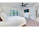 Well-lit bedroom showcasing a large window, ceiling fan, and a modern dresser with wall-mounted TV at 276 Caserta Ct, North Venice, FL 34275