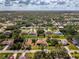 Aerial view of a single-story home with a tile roof surrounded by a lush green lawn in a residential area at 2799 Algardi Ln, North Port, FL 34286