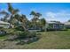 A sprawling backyard with lush landscaping, a screened lanai, and palm trees at 316 Wexford Ter # 167, Venice, FL 34293