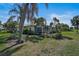 A sprawling backyard with lush landscaping, a screened lanai, and palm trees at 316 Wexford Ter # 167, Venice, FL 34293