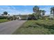 A long driveway leads to a carport with an outdoor storage unit and green doors at 316 Wexford Ter # 167, Venice, FL 34293