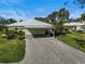 Charming home showcasing a carport, well-maintained lawn, and colorful landscaping at 316 Wexford Ter # 167, Venice, FL 34293