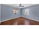 Bedroom with wood floors, ceiling fan, and ample natural light from two windows at 3716 Dunbar Rd, Venice, FL 34293