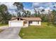 Charming single-story home with a garage, cream-colored paint, and a spacious front yard at 3716 Dunbar Rd, Venice, FL 34293
