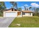 Single-story home featuring a freshly painted white garage door at 3716 Dunbar Rd, Venice, FL 34293