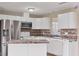 Well-equipped kitchen boasts stainless steel refrigerator and microwave with stone countertops at 3716 Dunbar Rd, Venice, FL 34293