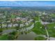 Stunning aerial view showcasing a picturesque community with beautiful homes, a golf course, and serene lakes at 385 N Point Rd # 404, Osprey, FL 34229