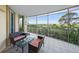 Screened balcony with comfortable seating offers tranquil views of nature at 385 N Point Rd # 404, Osprey, FL 34229