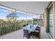 Large, screened balcony with a dining table and chairs, offering scenic water and nature views at 385 N Point Rd # 404, Osprey, FL 34229
