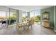 Sunlit dining area with floor-to-ceiling windows, balcony access, and stylish decor at 385 N Point Rd # 404, Osprey, FL 34229