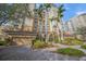 Beautiful condo building featuring an attached garage, lush landscaping, and a fountain at 385 N Point Rd # 404, Osprey, FL 34229