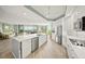 Open kitchen with stainless appliances, white counters and cabinetry, and an adjacent living area with balcony access at 385 N Point Rd # 404, Osprey, FL 34229