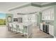 Bright kitchen features white cabinetry, stainless steel appliances, oversized island, and a built-in wine fridge at 385 N Point Rd # 404, Osprey, FL 34229