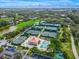 Picturesque aerial view of tennis courts, a refreshing pool, and well-manicured landscaping at 385 N Point Rd # 404, Osprey, FL 34229