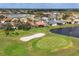 Stunning aerial view of a golf course community with lush green fairways, serene lake, and beautiful single Gathering homes at 446 Pinewood Lake Dr, Venice, FL 34285