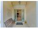 Charming home entrance featuring double doors, a bench, and a view into the living area at 446 Pinewood Lake Dr, Venice, FL 34285