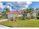 This single-story home features a red tile roof, a two-car garage, and beautifully maintained landscaping at 446 Pinewood Lake Dr, Venice, FL 34285