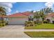 Charming single-story home with a red tile roof, a two-car garage, and beautifully maintained landscaping at 446 Pinewood Lake Dr, Venice, FL 34285