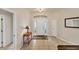 A bright foyer featuring tile flooring, a decorative light fixture, and a view of the front door at 446 Pinewood Lake Dr, Venice, FL 34285