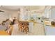 Open kitchen with tile floors, breakfast bar, white cabinets, and stainless steel appliances at 446 Pinewood Lake Dr, Venice, FL 34285
