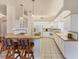 Bright kitchen with breakfast bar, white cabinets, tile floors, and modern appliances at 446 Pinewood Lake Dr, Venice, FL 34285