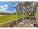 Serene screened lanai with seating area and peaceful views of the golf course at 446 Pinewood Lake Dr, Venice, FL 34285