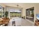 Inviting lanai with ceiling fan, comfortable seating, and picturesque golf course views at 446 Pinewood Lake Dr, Venice, FL 34285