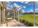 Charming lanai with seating, overlooking lush landscaping and golf course views at 446 Pinewood Lake Dr, Venice, FL 34285