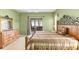 Cozy main bedroom featuring carpet floors, an iron bed frame, and outdoor access at 446 Pinewood Lake Dr, Venice, FL 34285