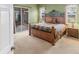 Cozy main bedroom featuring carpet floors, an iron bed frame, and outdoor access at 446 Pinewood Lake Dr, Venice, FL 34285