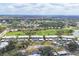 Aerial view of the condo community with a golf course, lakes, and tropical landscaping at 454 Cerromar Rd # 172, Venice, FL 34293
