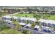 Aerial view of the condo community with carports, mature landscaping, and golf course at 454 Cerromar Rd # 172, Venice, FL 34293