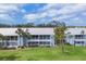 Two-story condo complex featuring light blue siding, white trim, and well-manicured landscaping at 454 Cerromar Rd # 172, Venice, FL 34293