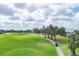Scenic golf course with lush green grass and a golf cart driving along the path at 454 Cerromar Rd # 172, Venice, FL 34293