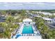 Aerial view of a community pool surrounded by lounge chairs, palm trees, and lush landscaping at 454 Cerromar Rd # 172, Venice, FL 34293