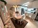 Bright dining room area with chandelier and wood table adjacent to open kitchen at 473 Sharks Pt, North Port, FL 34287