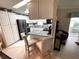 Kitchen area showcasing a granite-topped island with chairs and white appliances and cabinets at 473 Sharks Pt, North Port, FL 34287