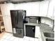 Functional kitchen features white cabinets, granite counters, and modern appliances at 473 Sharks Pt, North Port, FL 34287