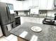 Well-lit kitchen with white cabinets, granite countertops, and stainless steel appliances at 473 Sharks Pt, North Port, FL 34287