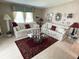 Cozy living room featuring two sofas, glass coffee table, decorative rug, and patterned walls at 473 Sharks Pt, North Port, FL 34287
