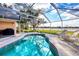Gorgeous turquoise pool with tiled accents in a screened in enclosure with water views and lounge chairs at 5051 Greenway Dr, North Port, FL 34287