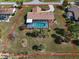 An aerial view of the property including a screened pool, tropical trees, landscaping, and yard at 5061 Richmond Ter, North Port, FL 34287
