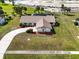 An overhead shot of a charming home with a tile roof, a circular driveway, and verdant landscaping at 5061 Richmond Ter, North Port, FL 34287
