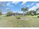 Expansive backyard featuring a screened-in pool, lush lawn, and tropical landscaping at 5061 Richmond Ter, North Port, FL 34287