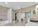 Open bathroom featuring bathtub, glass block window and double closets at 5061 Richmond Ter, North Port, FL 34287