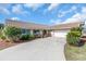 Charming single-story home featuring a tile roof, manicured landscaping, and an inviting driveway leading to a two-car garage at 5061 Richmond Ter, North Port, FL 34287